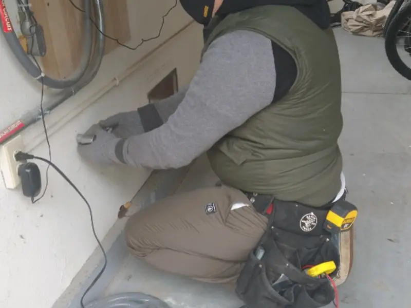 Electrician performing outlet wiring in a Olathe garage